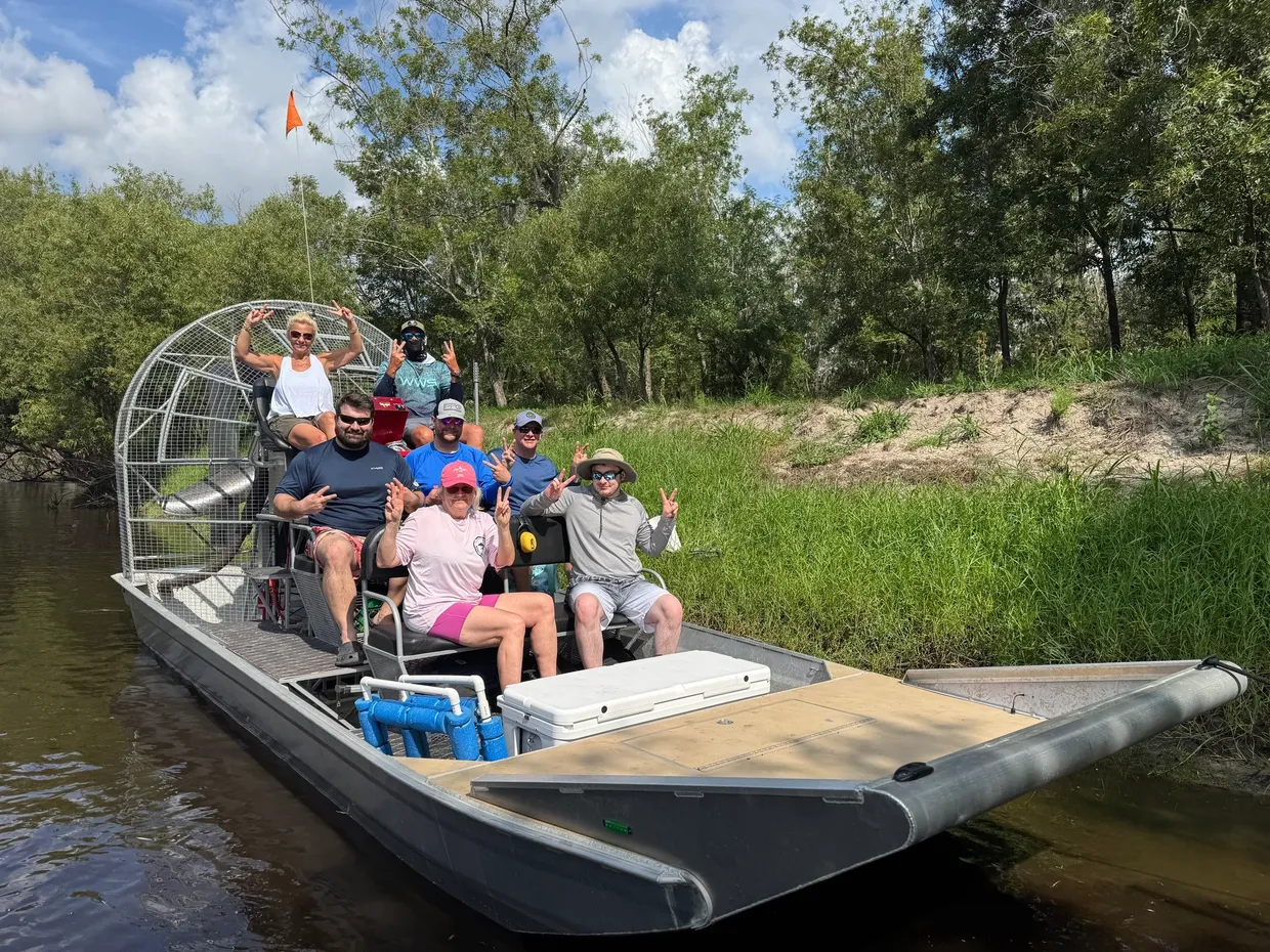 Tourists enjoying an airboat tour through the scenic river and wetlands near Arcadia, Florida, surrounded by lush greenery and nature.